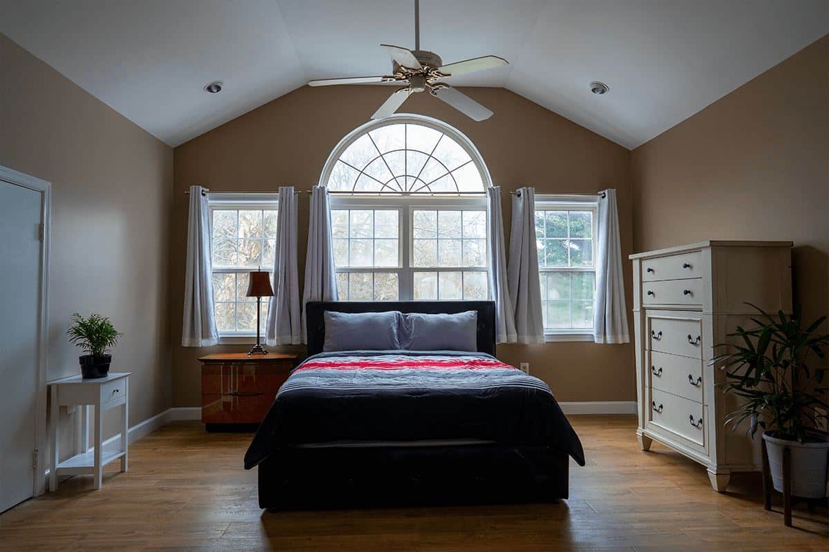 A bedroom with an arched window at the Arnold home