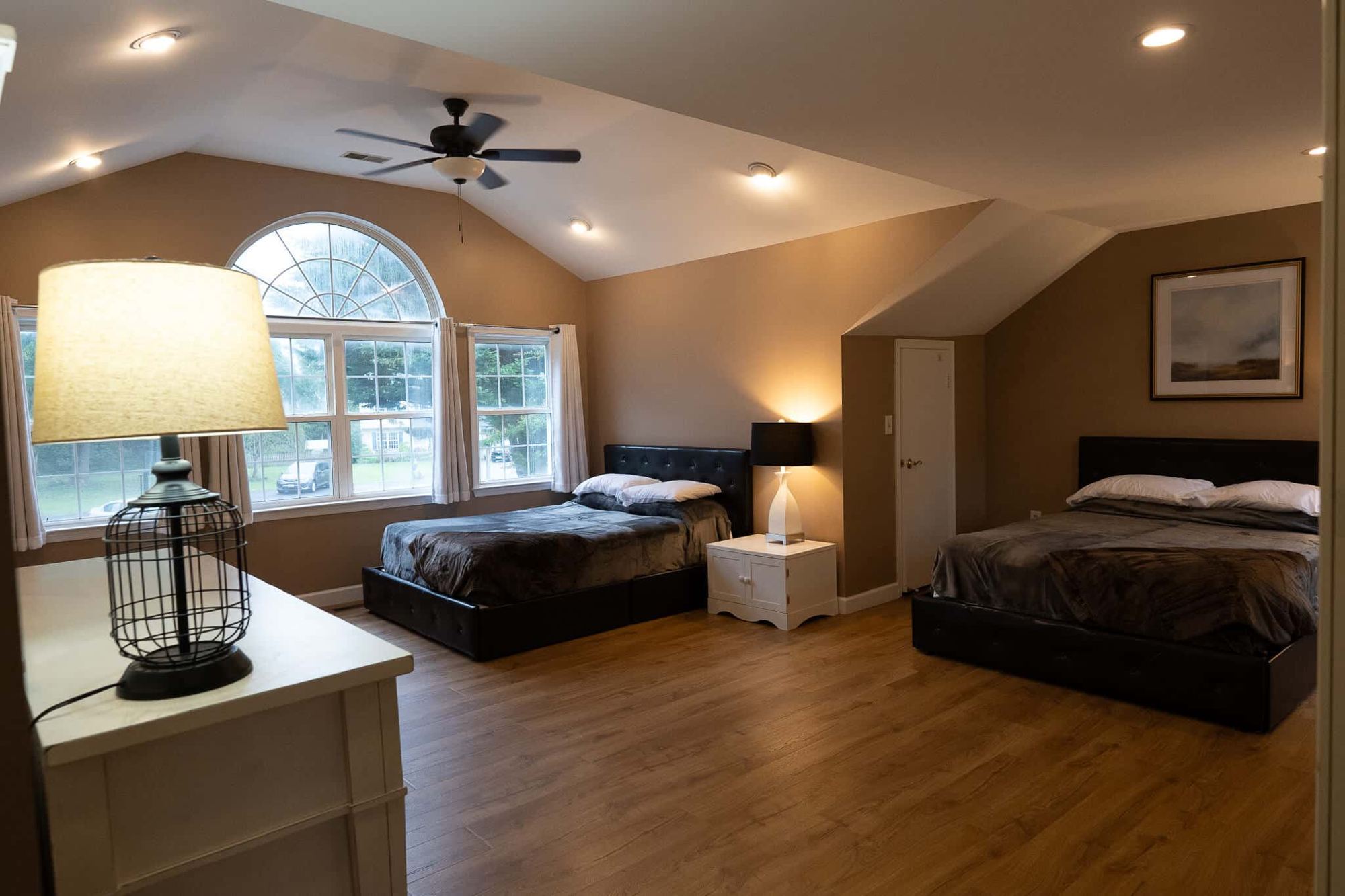 A bedroom with two beds under a vaulted ceiling at the Arnold home
