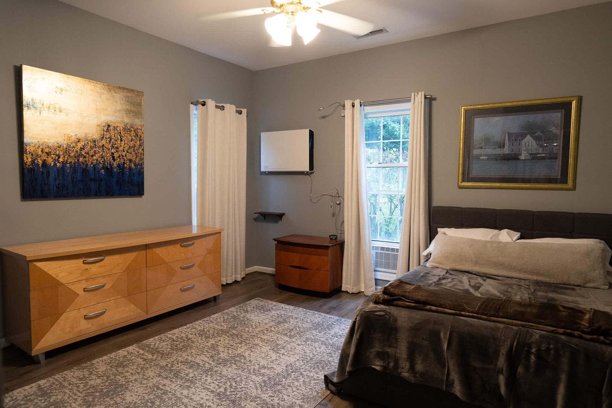 A bedroom with grey walls and a wide dresser at the Arnold home