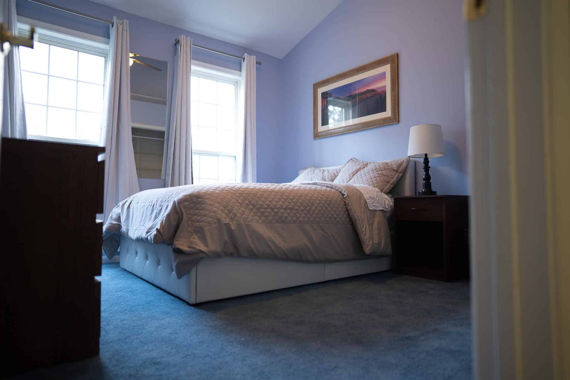 A lavender bedroom with a queen bed at the Arnold home