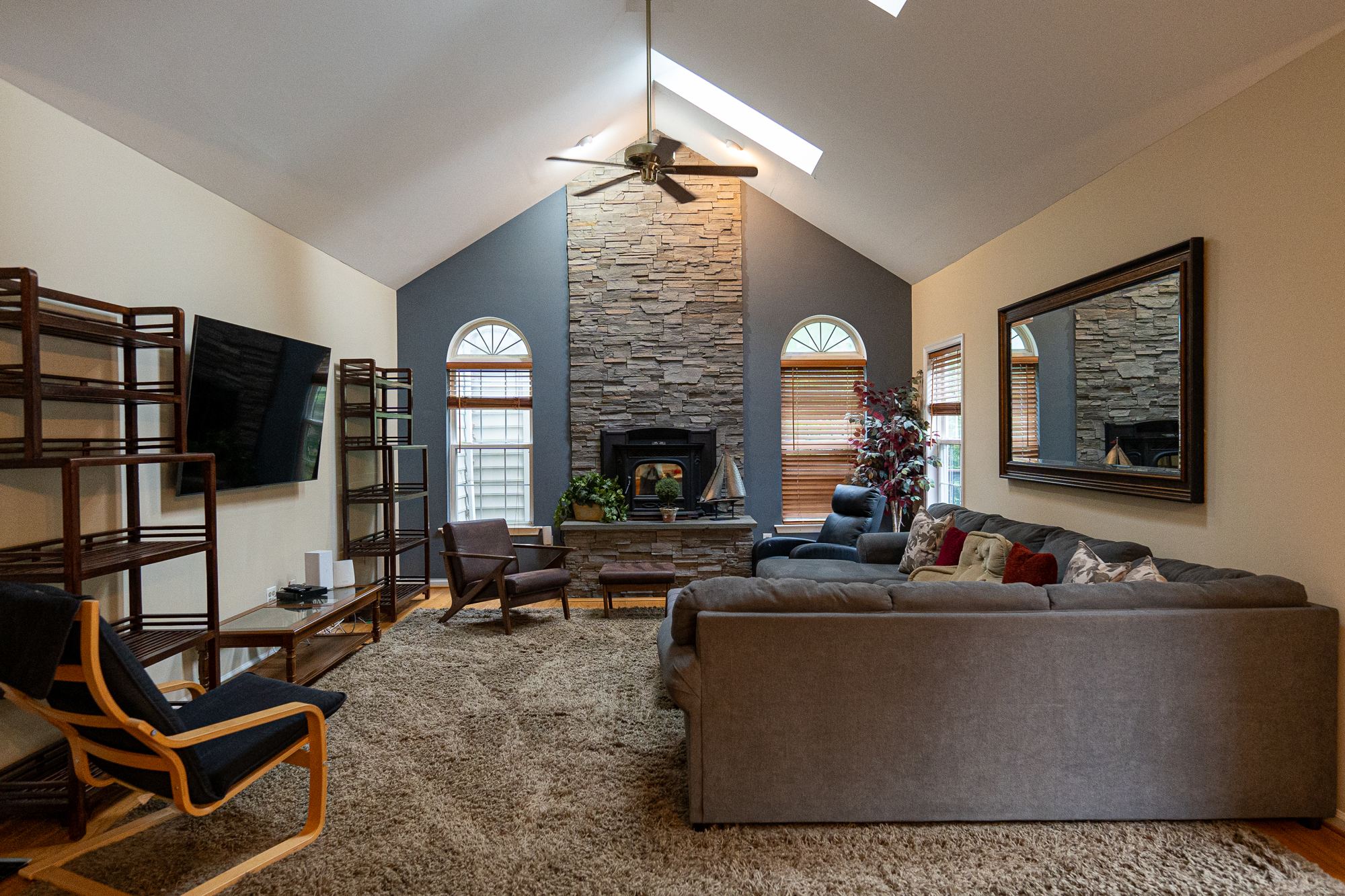 Vaulted living room with a stone fireplace at the Arnold home