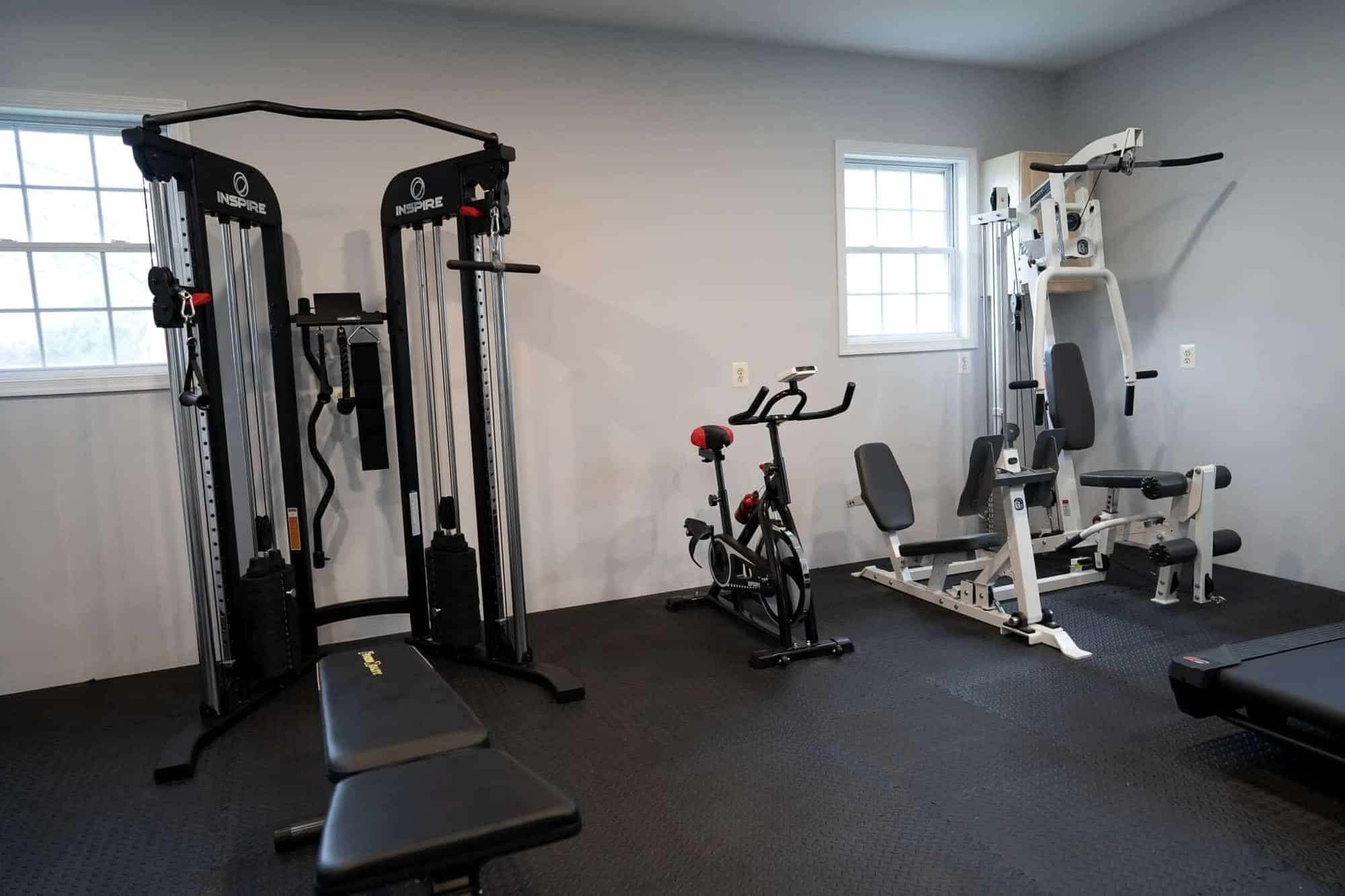 Cable machine, exercise bike and bench in the gym at the Arnold home