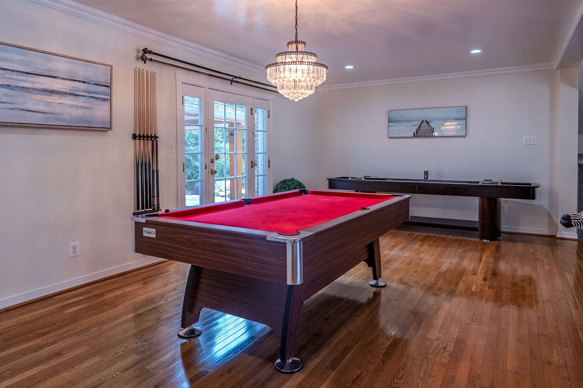 The game room with a pool table and chandelier at the Silver Spring home